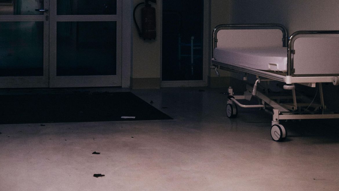 Ein leeres Bett steht auf einem Krankenhausflur.