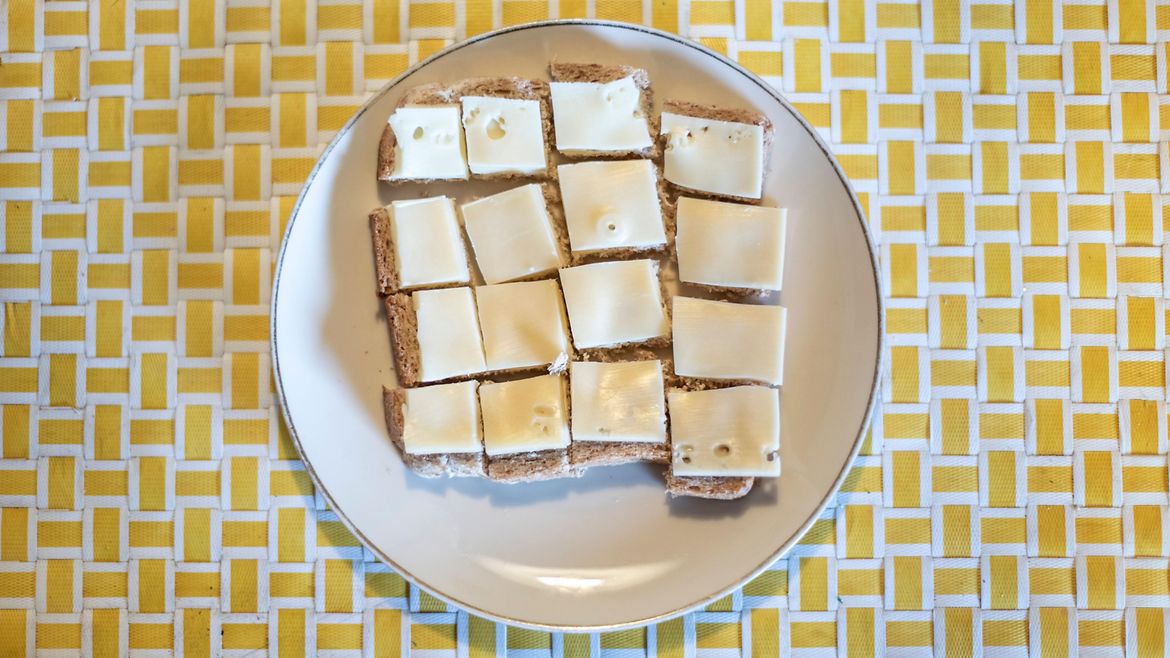 Ein Teller mit in Häppchen geschnittenem Käsebrot.