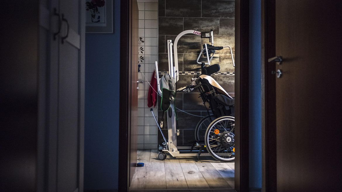 Durch die geöffnete Tür erkennt man einen Rollstuhl und einen Personenlifter.