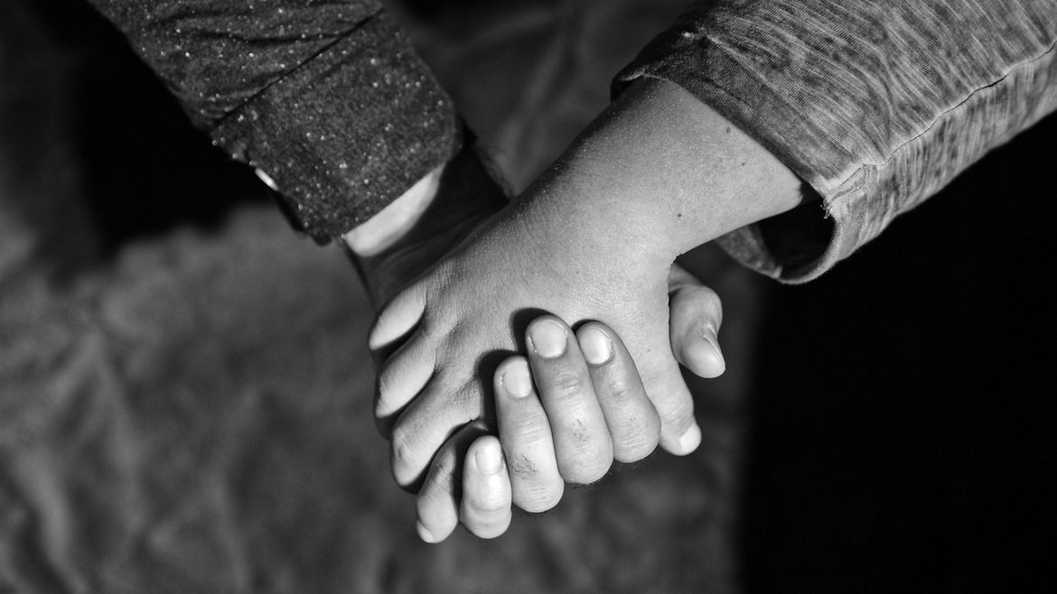 Zwei Hände halten sich gegenseitig.