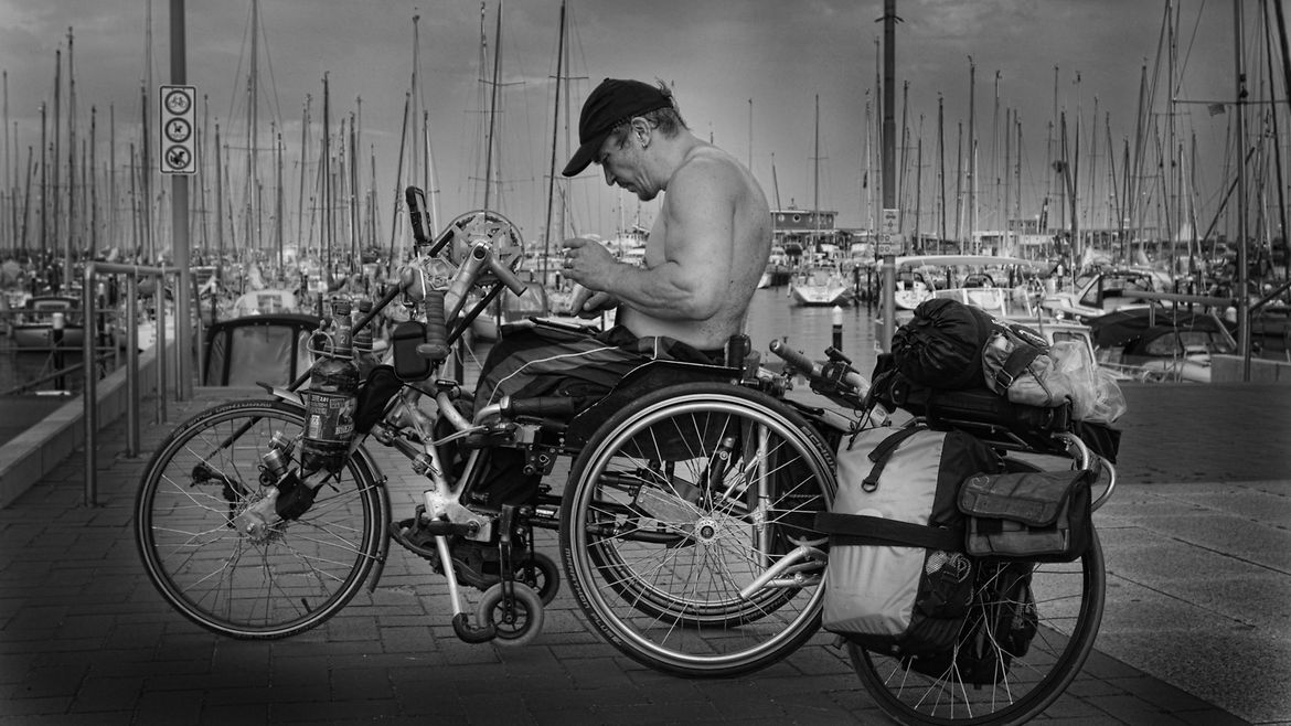 Ein Mann sitzt auf einem Handybike und bedient ein Navigationsgerät.