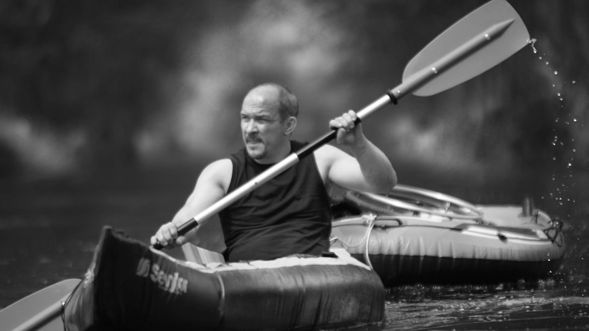 Ein Mann paddelt in einem Kanu auf dem Wasser.