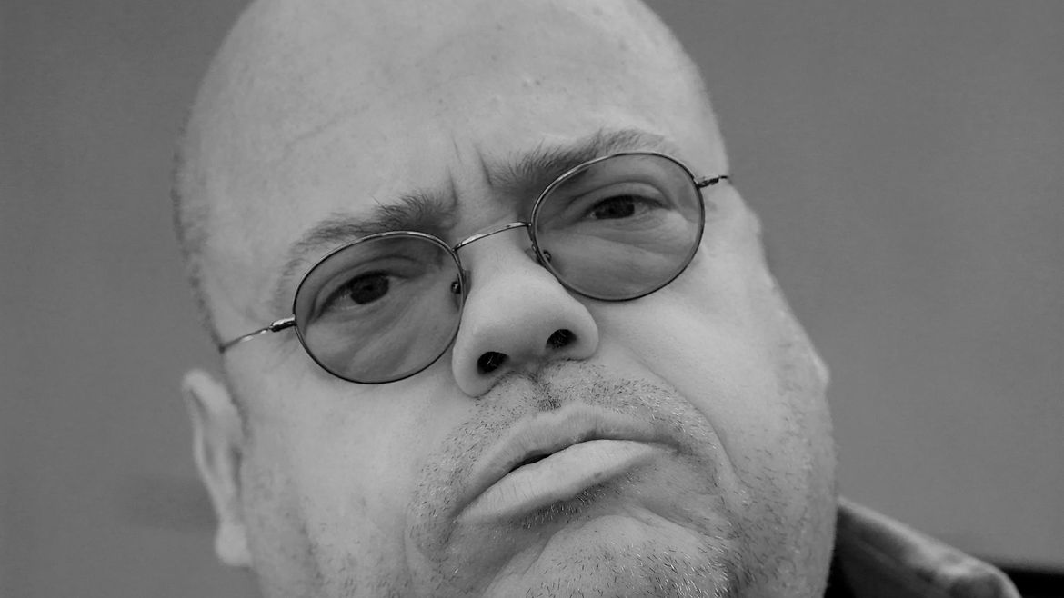 Porträt eines fülligen Mannes mit Brille.