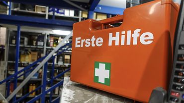 Verbandkasten - im Hintergrund Industrieregale.