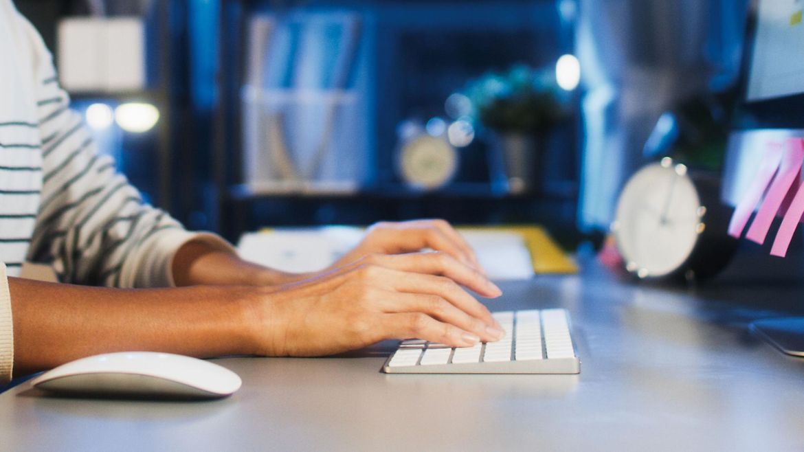 Zeitmanagement im Homeoffice Junger Mann arbeitet spät abends am Computer.