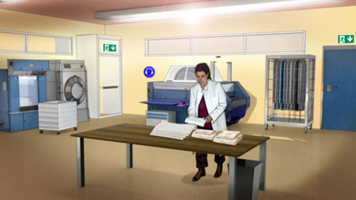 Mitarbeiterin in der Wäscherei legt auf einem Tisch Wäschestücke zusammen. Im Hintergrund stehen eine große Waschmaschine und eine Heißmangel..