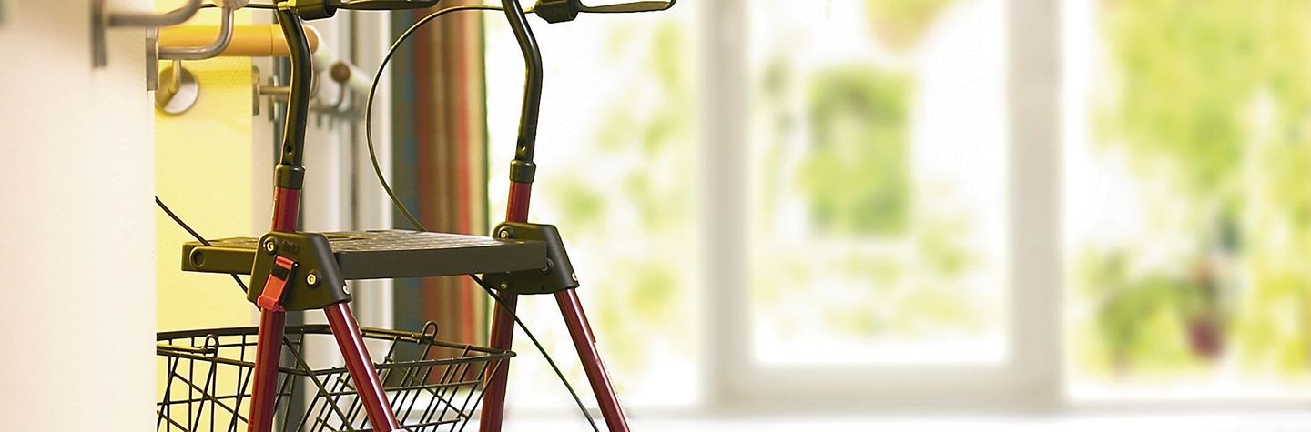 Stationäre Pflege Kopfbild Ein Rollator steht in einem Flur