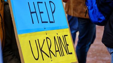 Karton beklebt mit den gelb-blauen Farben der ukrainischen Flagge und den Worten "Help Ukraine"