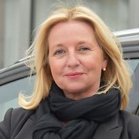 Aufsichtsperson Aufsichtsperson Ruth Giersch steht vor einem Auto und blättert in Unterlagen.