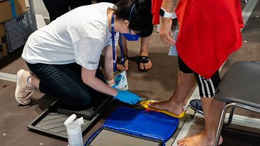 Healthy Athletes überprüfen die Fußgesundheit der Athletinnen und Athleten Healthy Athletes überprüfen die Fußgesundheit der Athletinnen und Athleten, messen die Schuhgröße, damit Stolpergefahren bei den Spielen präveniert werden