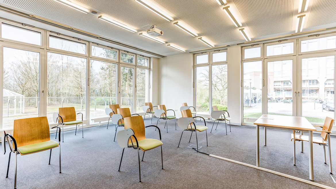 Mehrere Stühle mit klappbaren Tischen stehen in Reihen in einem Raum.
Ein Seminarraum im BG Klinikum Hamburg