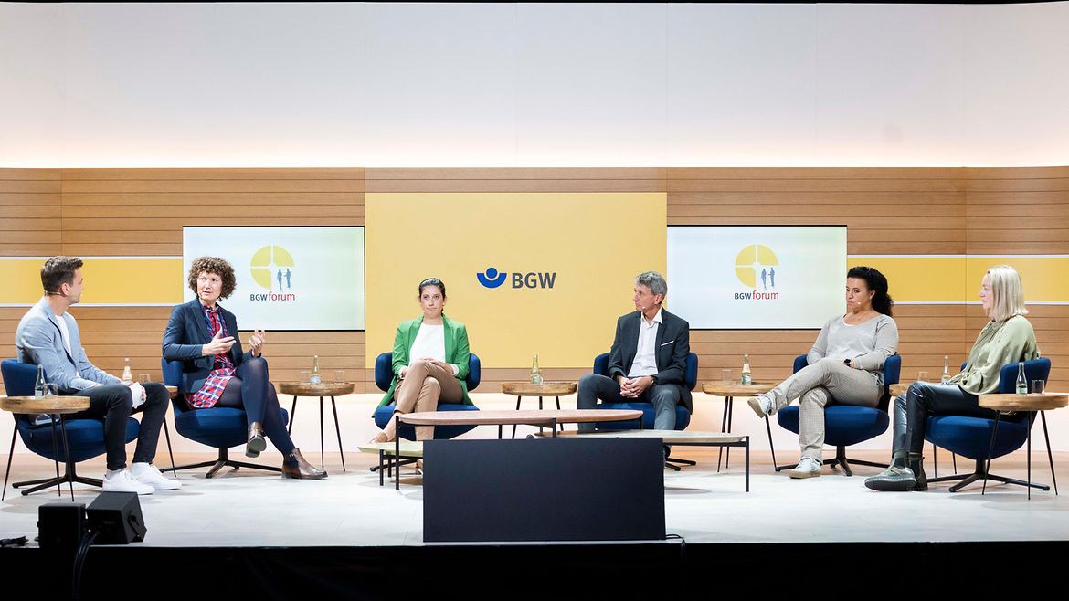 Sechs Personen - vier Frauen und zwei Männer sitzen auf einem Podium und diskutieren.