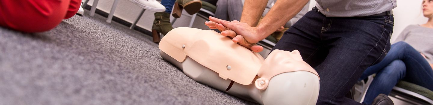 Ersthelfer trainiert Wiederbelebungsmaßnahmen an Dummy