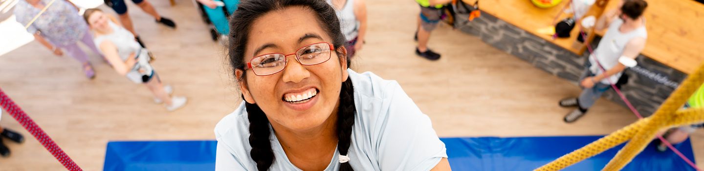 Frau klettert am BGW-Kletterturm