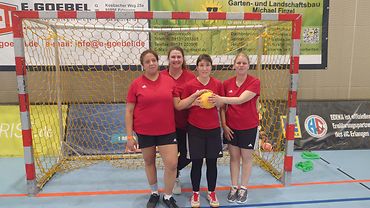 Drei Handballerinnen und die Trainerin vom Verein Werder stehen nebeneinander im Tor und halten einen Ball.