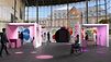 Visualisierung der Ausstellung: 5 Ausstellungsboxen in einer großen Halle mit großer Fensterfront, dahinter ein Gebäude 