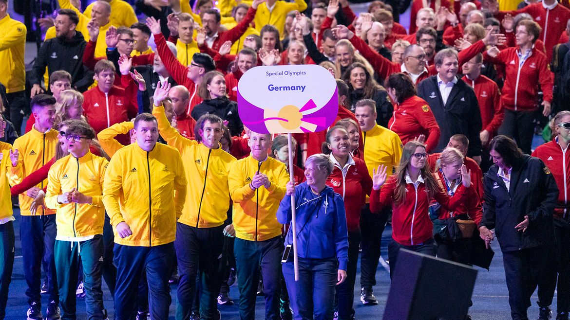 Die TeamSOD-Delegation läuft in gelben, roten und schwarzen Trainingsjacken ins Olympiastadion ein.