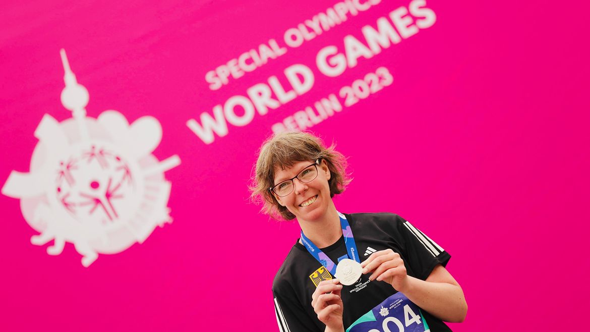 Annika Meissner mit Silbermedaille um den Hals vor pinker Wand mit SOWG-2023-Schriftzug