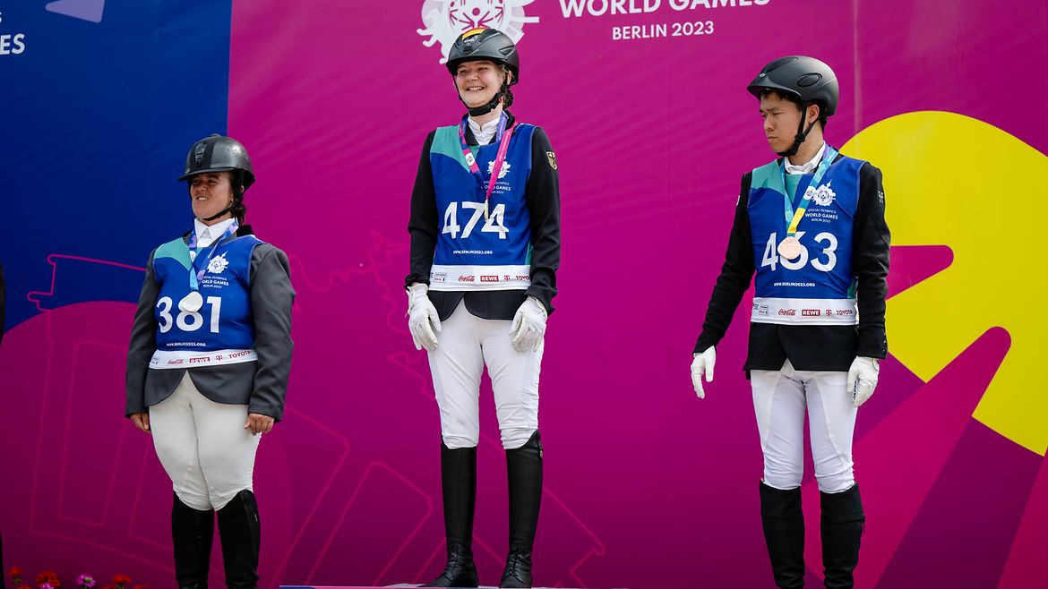 Lisa Preiss steht in der Mitte eines Siegertreppchens, links von ihr die Italienerin, rechts von ihr der Japaner.