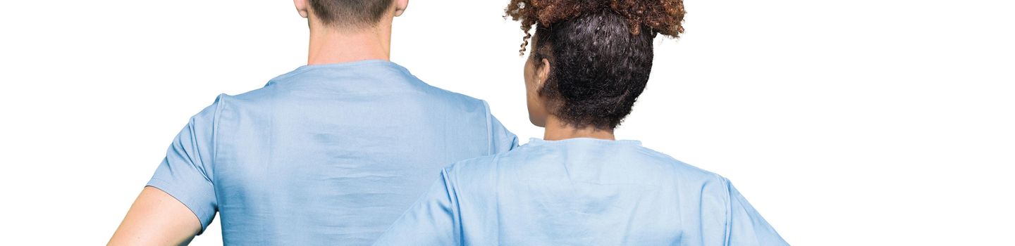 Zwei Personen in blauer Pflegekleidung von hinten.