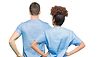 Zwei Personen in blauer Pflegekleidung von hinten.