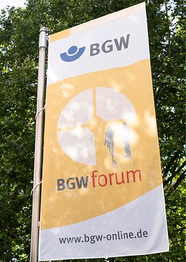 Eine Flagge mit dem logo des BGW forum vor einem Baum