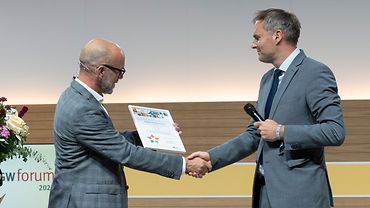 Axel Lottermoser (links) von der BGW überreicht Torsten Weiner, Pflegedirektor vom BG Klinikum Hamburg-Boberg, die Auszeichnung als integrationsfreundlicher Betrieb. Die Männer schütteln sich die Hand. 