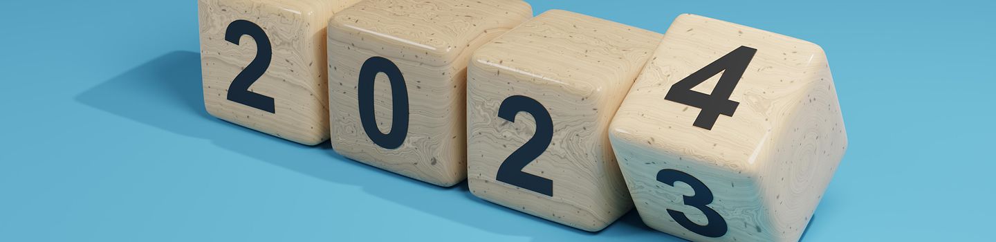 Holzklötze mit einzelnen Zahlen 2023 und 2024 liegen nebeneinander auf blauem Hintergrund - die letzte Zahl wird von 3 auf 4 gekippt.