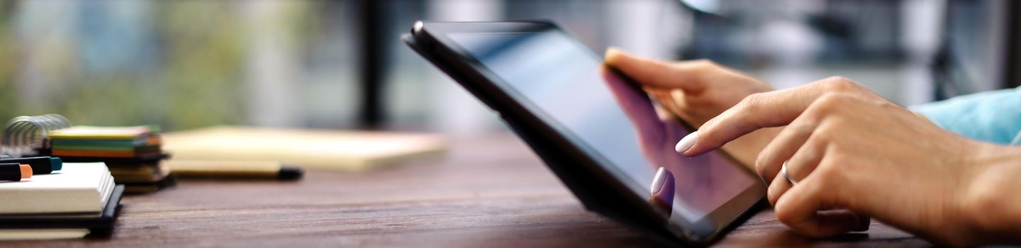Meine Reha Frauenhände tippen auf das Touchscreen eines tablets.