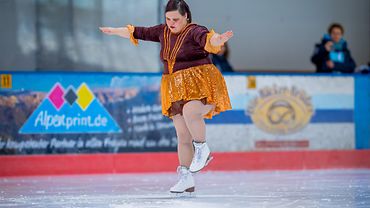 Eine Athletin mit Schlittschuhen in einer Eiskunsthalle.